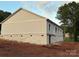 A look at the side of a single story home with light gray siding and a brick foundation on a large lot at 63 Cornerstone Dr, Taylorsville, NC 28681