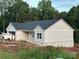 Charming single story home with light gray siding, a dark roof, and a brick foundation in a wooded area at 63 Cornerstone Dr, Taylorsville, NC 28681