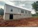 The rear of a light-gray home shows a brick foundation and several windows at 63 Cornerstone Dr, Taylorsville, NC 28681