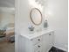 Bathroom featuring white cabinets, a round wood trimmed mirror, and modern lighting fixtures at 7931 Baylis Dr, Huntersville, NC 28078