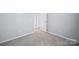 Bedroom featuring carpet, white walls, and an open closet with a door at 7931 Baylis Dr, Huntersville, NC 28078