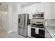 Modern kitchen with stainless steel appliances, white cabinets, and granite countertops at 7931 Baylis Dr, Huntersville, NC 28078