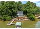Beautiful waterfront home featuring a private dock and boat house surrounded by lush trees at 812 Bell Post Rd, Belmont, NC 28012