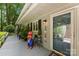 Inviting front porch with patriotic decor, a charming dog statue, and a beautifully designed front door at 812 Bell Post Rd, Belmont, NC 28012