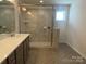 Bathroom featuring double vanity, walk-in shower with glass door and herringbone tile floor at 9108 Dulwich Dr # Ken0074, Charlotte, NC 28215