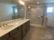 Bright bathroom with double vanity, walk-in shower featuring tile surround and glass door at 9108 Dulwich Dr # Ken0074, Charlotte, NC 28215