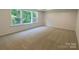 Large bedroom with neutral carpet and abundant natural light from a triple window at 9108 Dulwich Dr # Ken0074, Charlotte, NC 28215