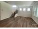 Open-concept living room with hardwood floors, natural light, and elegant staircase leading upstairs at 9108 Dulwich Dr # Ken0074, Charlotte, NC 28215
