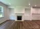Bright living room boasts a fireplace, built-in shelving, and wood-look flooring at 9108 Dulwich Dr # Ken0074, Charlotte, NC 28215