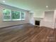 Cozy living room featuring hardwood floors, large windows, a fireplace, and built-in shelving at 9108 Dulwich Dr # Ken0074, Charlotte, NC 28215