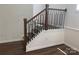 Staircase with wood railing, decorative iron spindles and wood-look flooring at 9108 Dulwich Dr # Ken0074, Charlotte, NC 28215