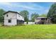 Spacious backyard showing a mix of grassy areas and various outbuildings at 1036 20Th Ne St, Hickory, NC 28601