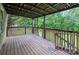 Covered back porch with wooden floor and railings overlooking a lush, green backyard at 1036 20Th Ne St, Hickory, NC 28601
