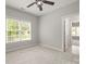 Bedroom with neutral walls, carpet flooring, ceiling fan, and a large window with backyard view at 11139 Tradition View Dr, Charlotte, NC 28269