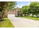 Charming brick home featuring a wide driveway, well-manicured lawn, mature trees, and a two-car garage at 11139 Tradition View Dr, Charlotte, NC 28269
