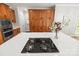 Kitchen island features black cooktop, lots of cabinets and drawers, white countertops and decorative vase of flowers at 11139 Tradition View Dr, Charlotte, NC 28269