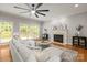 Inviting living room featuring a fireplace, large windows, and an expansive ceiling fan at 11139 Tradition View Dr, Charlotte, NC 28269