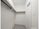 Compact walk-in closet with a white door, carpeted floor, and rod, offering essential storage solutions at 11139 Tradition View Dr, Charlotte, NC 28269