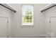 Bright walk-in closet with white walls, two doors, high window, and black metal rod shelving, offering ample storage space at 11139 Tradition View Dr, Charlotte, NC 28269