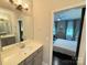 Bright bathroom includes a vanity sink and a view into the bedroom with ceiling fan at 114 Mint Ave # A, Mooresville, NC 28117