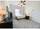 Bedroom with carpet, ceiling fan, a large window, and furnished with a TV and dressers at 1228 Tranquil Falls Ln, Matthews, NC 28104