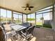 Screened patio features a dining table, chairs, and a ceiling fan, perfect for outdoor meals and relaxation at 1228 Tranquil Falls Ln, Matthews, NC 28104