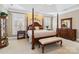 This bedroom features a four-poster bed, tray ceiling, and neutral color palette at 1302 Warrington Pl, Rock Hill, SC 29732
