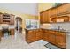 Open-concept kitchen area with wood cabinets, granite counters, and tile floors at 1302 Warrington Pl, Rock Hill, SC 29732