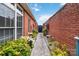 Paver walkway between brick walls with landscaped flower beds, leading to a black iron gate at 1302 Warrington Pl, Rock Hill, SC 29732