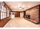 Comfortable living room with brick fireplace, ceiling fan and wood paneled walls at 1304 5Th Street Nw Cir, Hickory, NC 28601