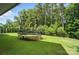Large backyard featuring a trampoline with a safety net, surrounded by green grass and mature trees at 16229 Loch Raven Rd, Huntersville, NC 28078