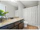 Bathroom featuring dark cabinets with a granite countertop, a white toilet, and a shower with a white curtain at 16229 Loch Raven Rd, Huntersville, NC 28078