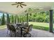 An ample covered patio has a dining table set and faces a beautifully landscaped backyard for serene outdoor enjoyment at 16229 Loch Raven Rd, Huntersville, NC 28078