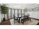Formal dining room featuring modern chandelier, large table with bench seating, and elegant window treatments at 16229 Loch Raven Rd, Huntersville, NC 28078