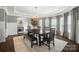 Formal dining room featuring modern chandelier, large table with bench seating, and elegant window treatments at 16229 Loch Raven Rd, Huntersville, NC 28078