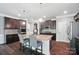 A spacious kitchen featuring dark wood cabinets, stainless steel appliances, and a large island with seating for two at 16229 Loch Raven Rd, Huntersville, NC 28078