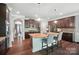 A spacious kitchen featuring dark wood cabinets, stainless steel appliances, and a large island with seating for two at 16229 Loch Raven Rd, Huntersville, NC 28078