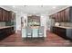 A spacious kitchen featuring dark wood cabinets, stainless steel appliances, and a large island with seating for two at 16229 Loch Raven Rd, Huntersville, NC 28078