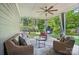 Covered patio with comfortable seating and ceiling fan, overlooking a backyard with green grass and mature trees at 16229 Loch Raven Rd, Huntersville, NC 28078