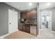 Basement wet bar features dark cabinets, granite countertops, a mini fridge, and tiled backsplash at 16229 Loch Raven Rd, Huntersville, NC 28078