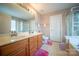 Bathroom featuring double sinks, ample counter space, and separate tub and shower at 16525 Kettlewell Ln, Charlotte, NC 28277