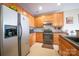 Functional kitchen with stainless steel appliances, wood cabinets, and gray countertops at 16525 Kettlewell Ln, Charlotte, NC 28277