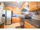 Spacious kitchen with stainless steel refrigerator, wood cabinets, and modern appliances at 16525 Kettlewell Ln, Charlotte, NC 28277
