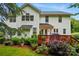 Rear of a white two-story home with a well-maintained deck, flowerbeds, and lush landscaping at 1720 Mountain Park Dr, Charlotte, NC 28214