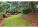 Beautiful backyard showing mature trees, lush green grass, and manicured landscape beds at 1720 Mountain Park Dr, Charlotte, NC 28214