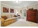 A bedroom features a comfortable couch and a large wooden dresser with a view outside at 1720 Mountain Park Dr, Charlotte, NC 28214