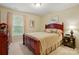 Comfortable bedroom with wood-framed bed, a window view, floral accents, and a decorative nightstand at 1720 Mountain Park Dr, Charlotte, NC 28214