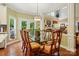 Well-lit dining room with a glass-top table, seating for eight, and views to the backyard at 1720 Mountain Park Dr, Charlotte, NC 28214