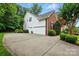 Exterior of home with white siding and brick accents, featuring a spacious concrete driveway and attached garage at 1720 Mountain Park Dr, Charlotte, NC 28214