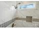 Close-up of marble shower, including fixtures, bench and tile niche at 1720 Mountain Park Dr, Charlotte, NC 28214